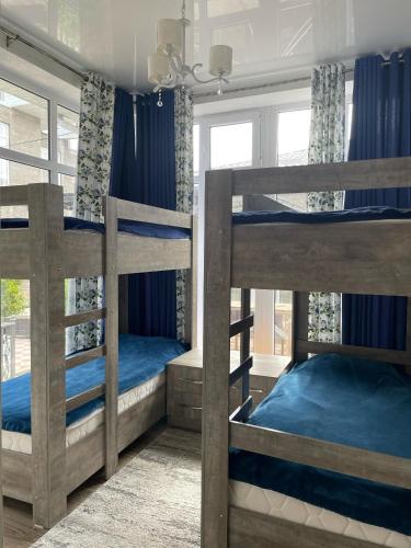 two bunk beds in a room with blue sheets at ЦО Париж in Chok-Tal