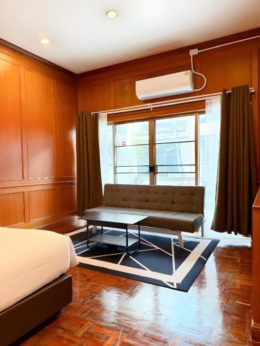a bedroom with a couch and a table in front of a window at Stay On Sukhumvit Soi 11 สเตย์ออน สุขุมวิท 11 in Makkasan