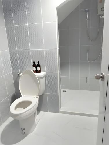a white bathroom with a toilet and a shower at Stay On Sukhumvit Soi 11 สเตย์ออน สุขุมวิท 11 in Makkasan