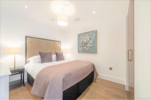 a bedroom with a large bed in a room with a lamp at Luxury flat in Covent Garden in London