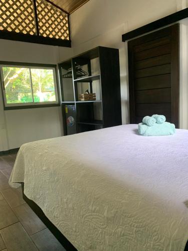 a bedroom with a bed with two towels on it at Playa Grande Lodge & Tree House in Cahuita