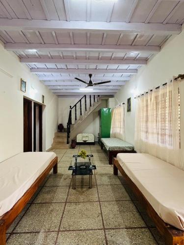 a room with two beds and a table in it at Coffee grove homestay in Chikmagalūr
