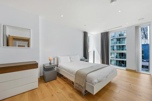 a white bedroom with a bed and a window at Paddington Ex LUX Flat in London