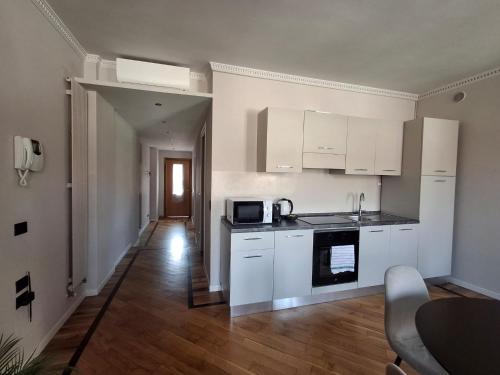 a kitchen with white cabinets and a wooden floor at Best View Boutique Apartments in Bergamo