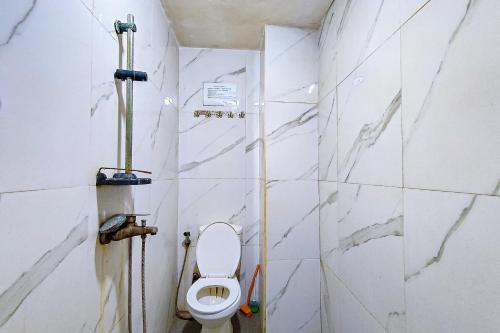 a bathroom with a toilet and a shower at Guest House 88 RedPartner in Jakarta