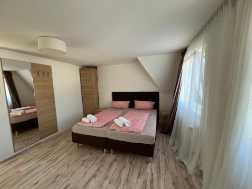 a bedroom with a bed with pink sheets and a mirror at Zum Feti Hotel und Restaurant in Rüdesheim am Rhein