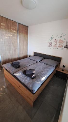 a bedroom with a bed with a wooden frame at Moderný 3 izbový dom so záhradou a terasou blízko Bratislavy in Slovenský Grob