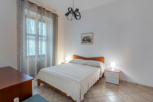 a white bedroom with a bed and a window at Casa Vacanze La Ginestra in Cava deʼ Tirreni