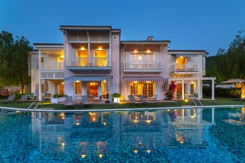a large house with a swimming pool in front of it at Portvillas by Villa Safiya in Göcek