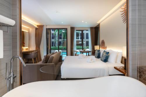 a hotel room with two beds and a living room at The Marin Phuket Kamala Beach in Kamala Beach