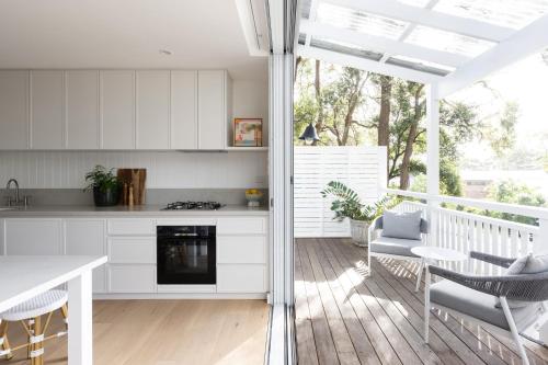 a kitchen with white cabinets and a table and chairs at Yachtsmans Paradise Retreat in Newport