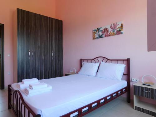 a bedroom with a large bed with white sheets at Villa Rosa in Vourvourou