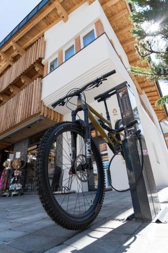 a bike parked on a stand in front of a building at Glanz & Glory Appartements Sölden in Sölden
