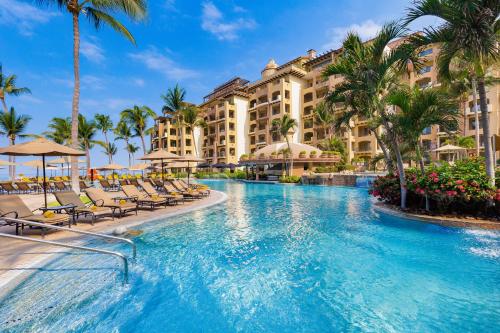 a pool at the resort with chairs and palm trees at Beachside Escape at Riviera Nayarit w Pool in Nuevo Vallarta