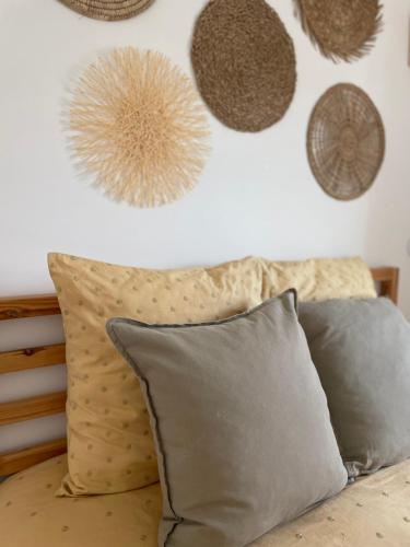 a bedroom with a bed with pillows and decorations on the wall at Casa da Avó in Sesimbra