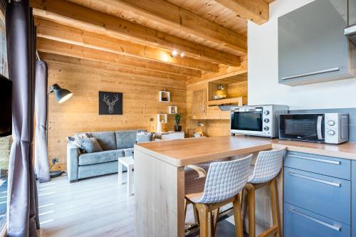 une cuisine et un salon avec une table et des chaises dans l'établissement Studio De Charme Montagne, à Notre-Dame-du-Pré