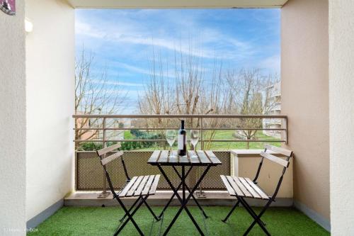 un balcon avec une table et deux chaises et une fenêtre dans l'établissement Le Tikehau 4pers, 10min Disneyland Paris, à Montévrain