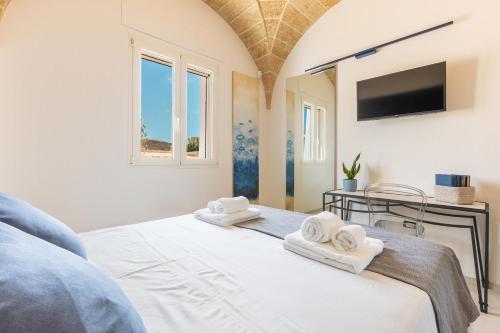 a bedroom with a bed with towels on it at Villa Demetra by SalentoInVacanzaCOM in Marina di Pescoluse