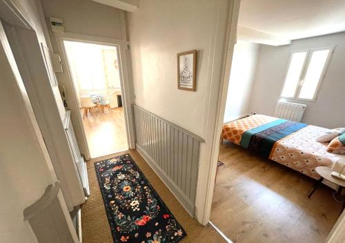 a bedroom with a bed and a hallway with a rug at L'Erable - Calme en Plein centre - 1er étage in Auch