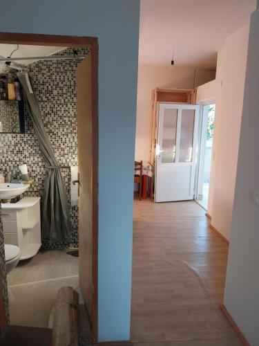 a hallway with a door leading into a room with a bathroom at Studio apartman u ruralnom okruženju in Donji Karin