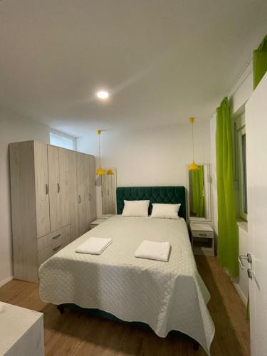 a bedroom with a large bed and green curtains at Deluxe Apartment 2-rooms in Herceg-Novi