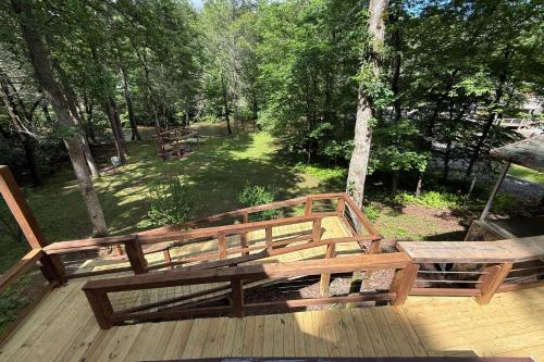a wooden deck with two benches on top of it at The Waters Edge Game room creek access firepit and tons of outdoor space in Copperhill