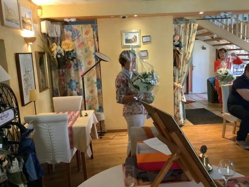 a woman holding a bouquet of flowers in a room at Auberge de Marville in Marville