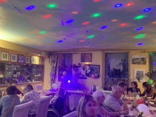 a group of people sitting around a room with lights on the ceiling at Auberge de Marville in Marville