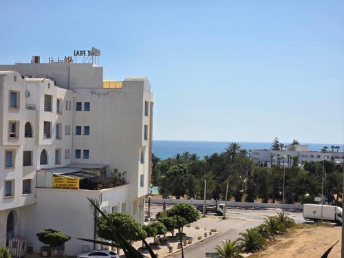 a view of a building with the ocean in the background at Luxurious two bedroom Appartement résidence La Fatimide in Hiboun