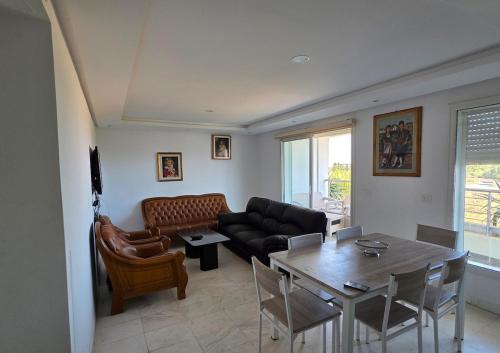 a living room with a couch and a table at Luxurious two bedroom Appartement résidence La Fatimide in Hiboun