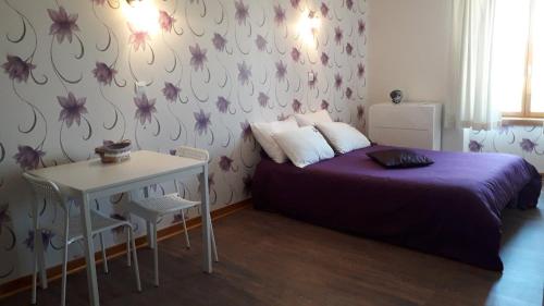 - une chambre avec un lit violet et une table dans l'établissement La Maison en Cézallier - Purple, à Marcenat