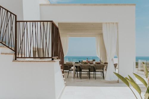 a dining room with a table and a view of the ocean at Villa Demetra by SalentoInVacanzaCOM in Marina di Pescoluse