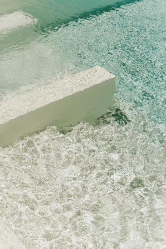 a pool of water with a stone in the middle at Villa Demetra by SalentoInVacanzaCOM in Marina di Pescoluse