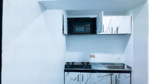 a kitchen with a sink and a microwave at DeMayafolo in Mama