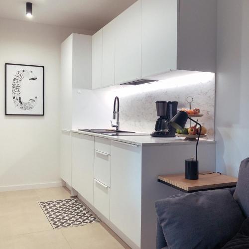 une cuisine avec des armoires blanches et un évier dans l'établissement Coco, Elegance and Serenity in Collioure, à Collioure