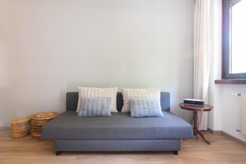a blue couch in a room with a window at appartamento centralissimo vista terme in Vittorio Veneto