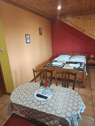 a room with two beds and a table with flowers on it at Skrzydlate Ranczo in Włodawa