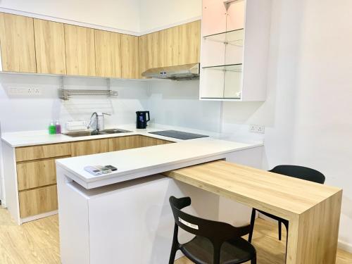 a kitchen with a white counter and a black chair at Deco Home @ Aru Suites in Kota Kinabalu