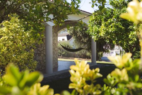 una vista di una casa dal giardino attraverso gli alberi di Casa das Milheirices a São Mamede