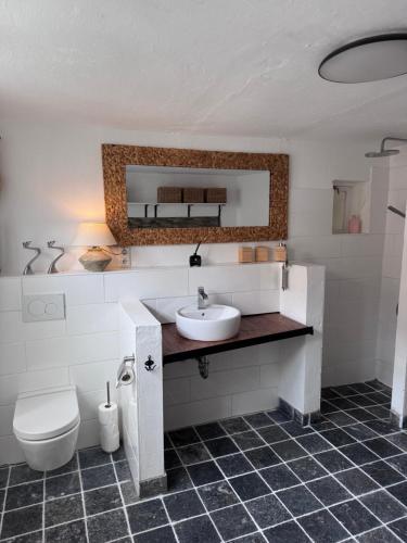 a bathroom with a sink and a toilet and a mirror at Altstadthaus No 18 in Lübeck