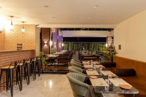 a restaurant with tables and chairs in a room at Hotel Money Plant in Jogeshwāri