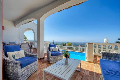 a patio with chairs and a table and a pool at Cabana do Monte in Santa Bárbara de Nexe