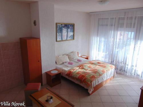 a bedroom with a bed and a large window at Villa Novak in Ohrid