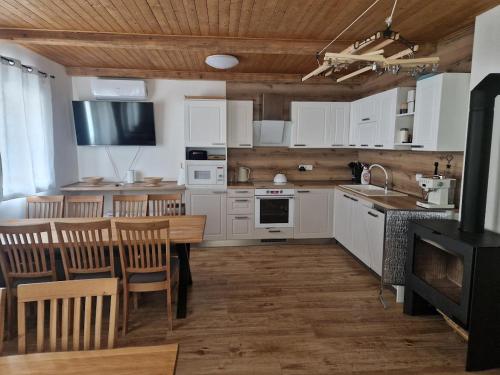 a kitchen with white cabinets and a table and chairs at Chalupa Herbortice in Cotkytle