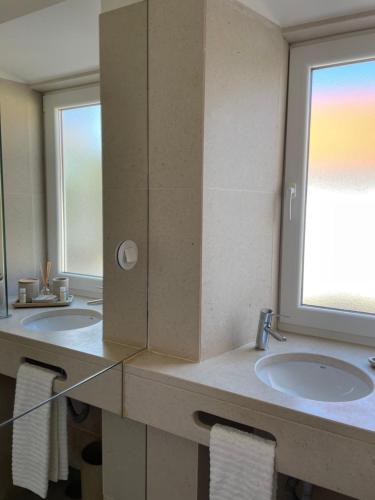 a bathroom with two sinks and a large mirror at Casa da Avó in Sesimbra
