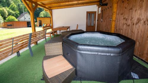 a large hot tub on a porch with a bench at Chalupa Herbortice in Cotkytle