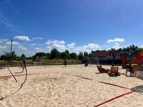 a playground with people playing in the sand at Olivina Park Spa - domki z dostępem do krytego basenu, saun, wyżywienia i atrakcji dla dzieci in Niechorze