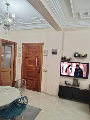 a living room with a tv on the wall at Bouchra in Martil