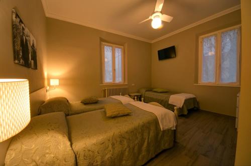 a room with two beds and a couch and windows at Hotel Ristorante Bologna in San Piero in Bagno