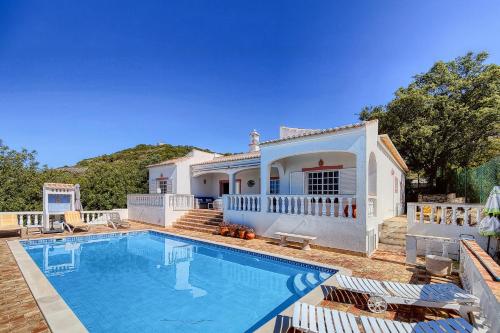 a villa with a swimming pool and a house at Cabana do Monte in Santa Bárbara de Nexe